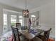 Dining room includes a wooden table with six chairs, with a staircase and entry in the background at 4290 Grand Teton Pkwy, Suwanee, GA 30024