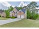 Exterior shot of a brick home with a long driveway, a two car garage, and lush green lawn at 4290 Grand Teton Pkwy, Suwanee, GA 30024