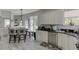 Eat-in kitchen features white cabinets, stainless appliances, stone countertops, and adjacent dining area at 4290 Grand Teton Pkwy, Suwanee, GA 30024