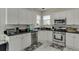 Well-lit kitchen featuring white cabinets, stainless steel appliances, and sleek black countertops at 4290 Grand Teton Pkwy, Suwanee, GA 30024