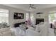 Cozy living room with white sofas, a fireplace, large windows and a ceiling fan at 4290 Grand Teton Pkwy, Suwanee, GA 30024