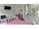 Playroom features pink carpet, a TV, and a staircase to another floor with a full railing at 4290 Grand Teton Pkwy, Suwanee, GA 30024
