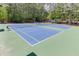 Well-maintained blue and green community tennis courts with a net and lighting at 4290 Grand Teton Pkwy, Suwanee, GA 30024