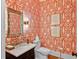 Stylish powder room features designer wallpaper, modern fixtures, and a marble countertop at 5134 Pratt Sw St, Covington, GA 30014