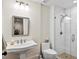 Modern bathroom featuring a pedestal sink, mirrored cabinet, glass enclosed shower, and stylish fixtures at 5134 Pratt Sw St, Covington, GA 30014