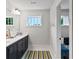 Modern bathroom with double vanity, sleek black cabinets, a large mirror, and natural light at 5134 Pratt Sw St, Covington, GA 30014
