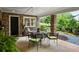 Relaxing covered patio featuring brick columns and a charming table setting, adjacent to landscaped yard at 5134 Pratt Sw St, Covington, GA 30014