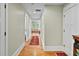 Inviting hallway featuring hardwood floors, white trim, and a glimpse into a cozy living space at 5134 Pratt Sw St, Covington, GA 30014