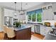 White kitchen with island, stainless appliances, and modern lighting at 5134 Pratt Sw St, Covington, GA 30014