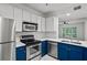 Modern kitchen featuring stainless steel appliances, white cabinets, and blue island at 1250 Parkwood Se Cir # 3101, Atlanta, GA 30339