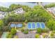 Aerial view of community tennis courts in a wooded area close to homes and a lake at 162 Greenbrier Way, Canton, GA 30114