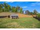 Backyard view featuring a shed, green lawn, and natural landscape, offering a serene and private outdoor space at 162 Greenbrier Way, Canton, GA 30114