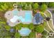 An aerial view of the community pool area with multiple pools, slides, seating, and well-manicured landscaping at 162 Greenbrier Way, Canton, GA 30114
