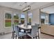 Bright dining room featuring a modern light fixture, large windows, and stylish blue chairs at 162 Greenbrier Way, Canton, GA 30114