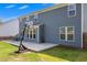 Back exterior view of a two-story home featuring a concrete patio, basketball hoop, and manicured lawn at 162 Greenbrier Way, Canton, GA 30114