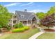 Charming home with a covered front porch, a manicured lawn, lush landscaping, and trees at 162 Greenbrier Way, Canton, GA 30114