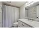Bathroom featuring a marble countertop, white vanity, updated faucet and a shower with modern curtain at 25 Ivy Gates Ne, Atlanta, GA 30342