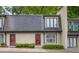 Two-story townhouse with a neutral exterior, red front doors, and well-maintained landscaping at 25 Ivy Gates Ne, Atlanta, GA 30342