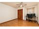 Clean bedroom with laminated floors, a ceiling fan, a double door closet, and a desk with multiple monitors at 4065 Maxanne Nw Dr, Kennesaw, GA 30144