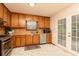 Traditional kitchen with wood cabinets and stainless steel appliances, with a door leading to the outdoor deck at 4065 Maxanne Nw Dr, Kennesaw, GA 30144
