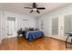Spacious main bedroom features hardwood floors, a ceiling fan, an ensuite bathroom, and balcony access through glass doors at 4065 Maxanne Nw Dr, Kennesaw, GA 30144
