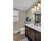 Updated bathroom boasts a modern vanity with granite countertop, brushed nickel fixtures, and a tiled shower at 4702 Sequoia Sw Dr, Lilburn, GA 30047