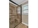 Bathroom shower with stone tile surround, glass door, and built in seat and toiletry space at 4702 Sequoia Sw Dr, Lilburn, GA 30047