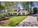Traditional two-story home with a driveway, a well-manicured lawn, and mature trees providing shade at 4702 Sequoia Sw Dr, Lilburn, GA 30047