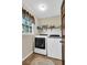 Clean laundry room with side-by-side washer and dryer units and overhead shelving at 4702 Sequoia Sw Dr, Lilburn, GA 30047