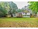 Large backyard view featuring a storage shed, a deck, and mature trees, creating a private outdoor oasis at 5105 Davidson Ne Rd, Marietta, GA 30068