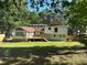 Spacious backyard featuring a deck and green grass surrounded by mature trees at 5105 Davidson Ne Rd, Marietta, GA 30068