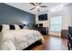 Well-lit bedroom with a modern ceiling fan, accent wall, and a large bed for a comfortable living space at 5105 Davidson Ne Rd, Marietta, GA 30068
