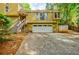 Close up view of a two-story house with a two-car garage, yellow siding, and stone accents at 5105 Davidson Ne Rd, Marietta, GA 30068