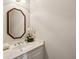 Bathroom vanity with an octagon mirror, white cabinets and faux flowers at 1824 Mallard Lake Dr, Marietta, GA 30068