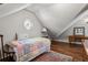 Sloped ceiling bedroom with wood floors, area rug and round window at 1824 Mallard Lake Dr, Marietta, GA 30068