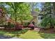 Charming two-story home featuring a well-manicured lawn with mature trees and beautiful, colorful landscaping at 1824 Mallard Lake Dr, Marietta, GA 30068