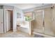 This light bathroom includes a shower and tub combination next to a large window at 233 Hampton Station Blvd, Canton, GA 30115