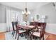 Formal dining room with a classic chandelier, hardwood floors, and ample seating for dinner guests at 233 Hampton Station Blvd, Canton, GA 30115