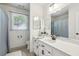 Bright bathroom featuring a single sink, a window for natural light, and white cabinets at 1390 Barclay Dr, Lawrenceville, GA 30043