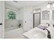 Clean bathroom featuring dual sinks, bathtub with tile surround, and natural light from the window at 1390 Barclay Dr, Lawrenceville, GA 30043