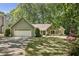 Charming single Gathering home featuring stone and siding details, lush landscaping, and an attached two-car garage at 1390 Barclay Dr, Lawrenceville, GA 30043