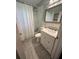 Cozy bathroom featuring white vanity, chrome fixtures, tiled floor and shower, plus elegant framed mirror at 1900 Meadow Ln, Decatur, GA 30032