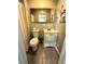 Cozy bathroom with a mirrored vanity, toilet, and shower with neutral colored wall and floor tiles at 1900 Meadow Ln, Decatur, GA 30032