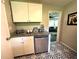 Kitchen with stainless steel dishwasher, granite countertop, and unique black and white patterned floor at 1900 Meadow Ln, Decatur, GA 30032