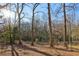 View of a wooded backyard with mature trees and a chainlink fence at 409 Katherine Ln, Woodstock, GA 30189