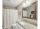 Bright bathroom with granite countertop, framed mirror, shower with white curtain, and white toilet at 409 Katherine Ln, Woodstock, GA 30189