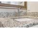 Close-up on the bathroom granite countertop with running water and a framed mirror at 409 Katherine Ln, Woodstock, GA 30189