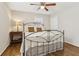 This bedroom has hardwood floors, a ceiling fan, a window, and a bed with decorative metal frame at 409 Katherine Ln, Woodstock, GA 30189