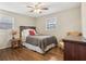 Cozy bedroom with hardwood floors, ceiling fan, and a red accent pillow on the bed at 409 Katherine Ln, Woodstock, GA 30189