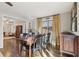 Sunlit dining room with hardwood floors, a wooden table, and decorative window curtains at 409 Katherine Ln, Woodstock, GA 30189